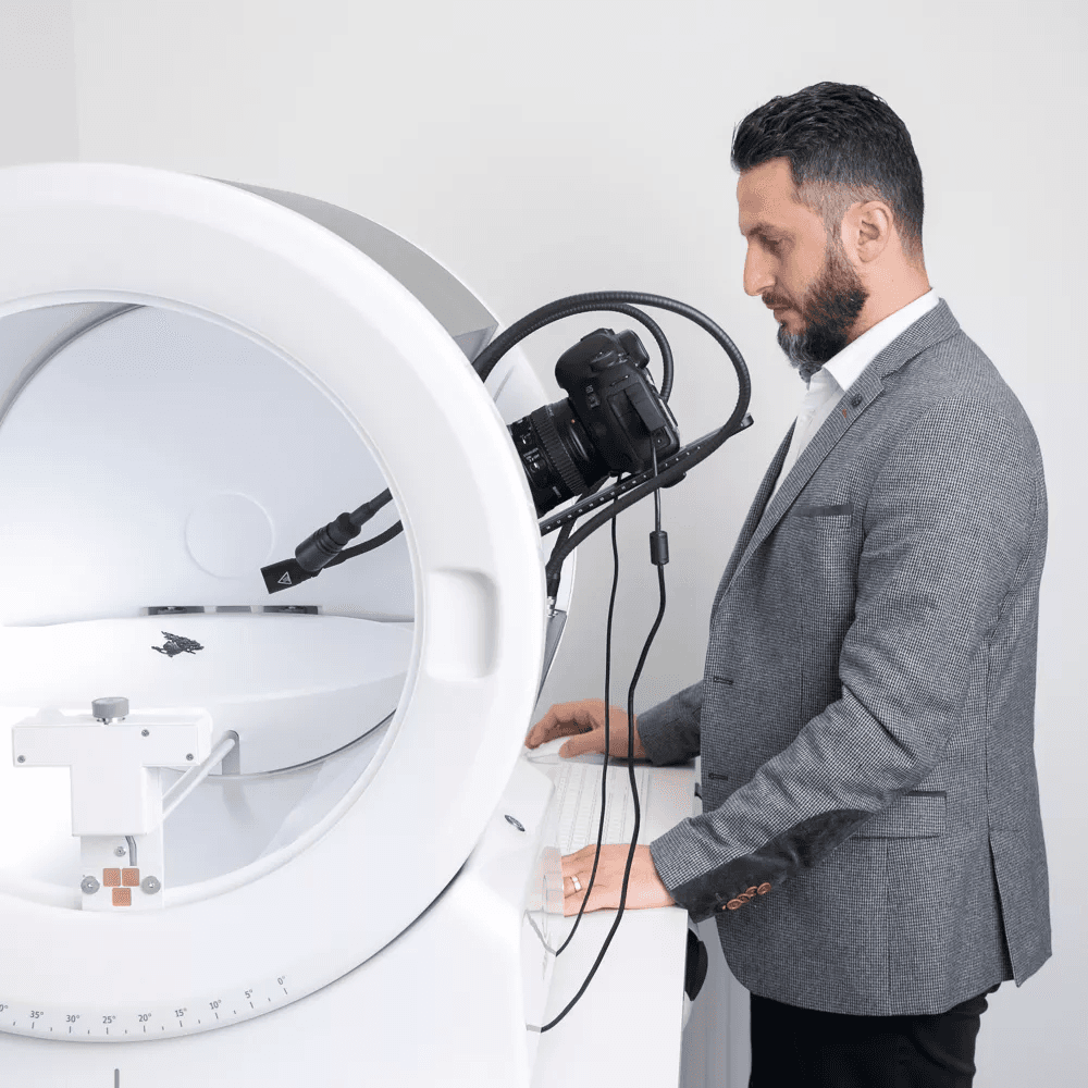 Uomo in abito mentre utilizza un dispositivo fotografico Orbitvu