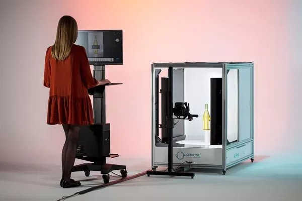 Un'operatrice utilizza uno studio fotografico automatizzato compatto per prodotti