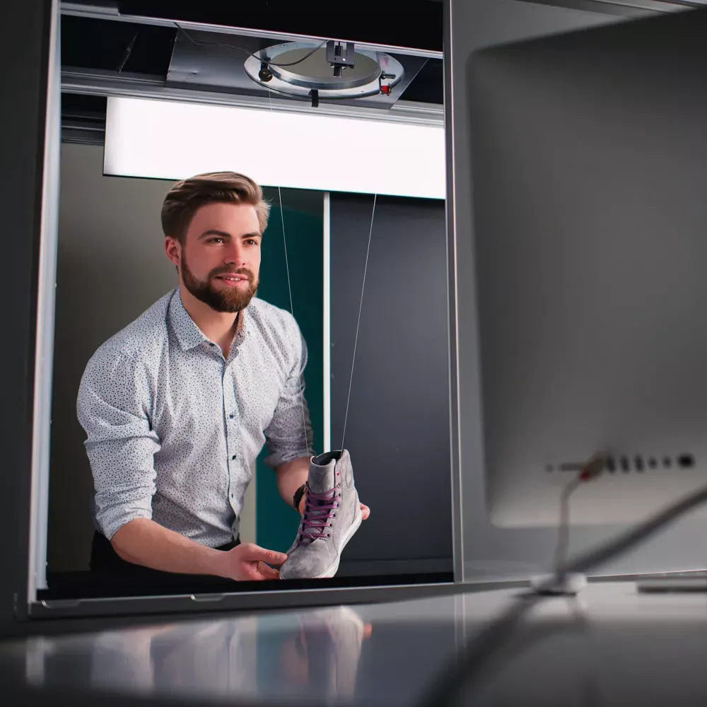 Uomo che prepara un prodotto per la fotografia professionale di scarpe