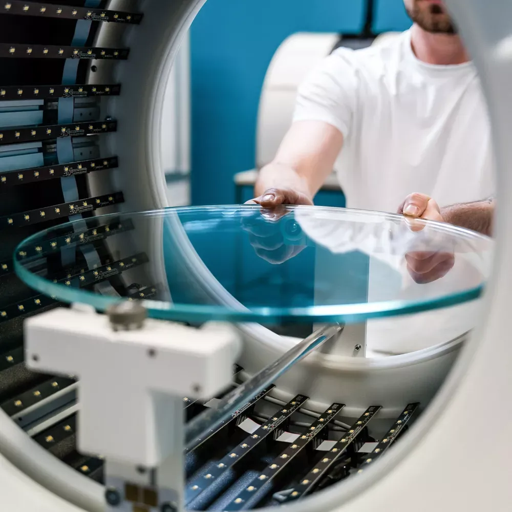 Un tecnico installa il piatto rotante in vetro in uno studio fotografico automatizzato